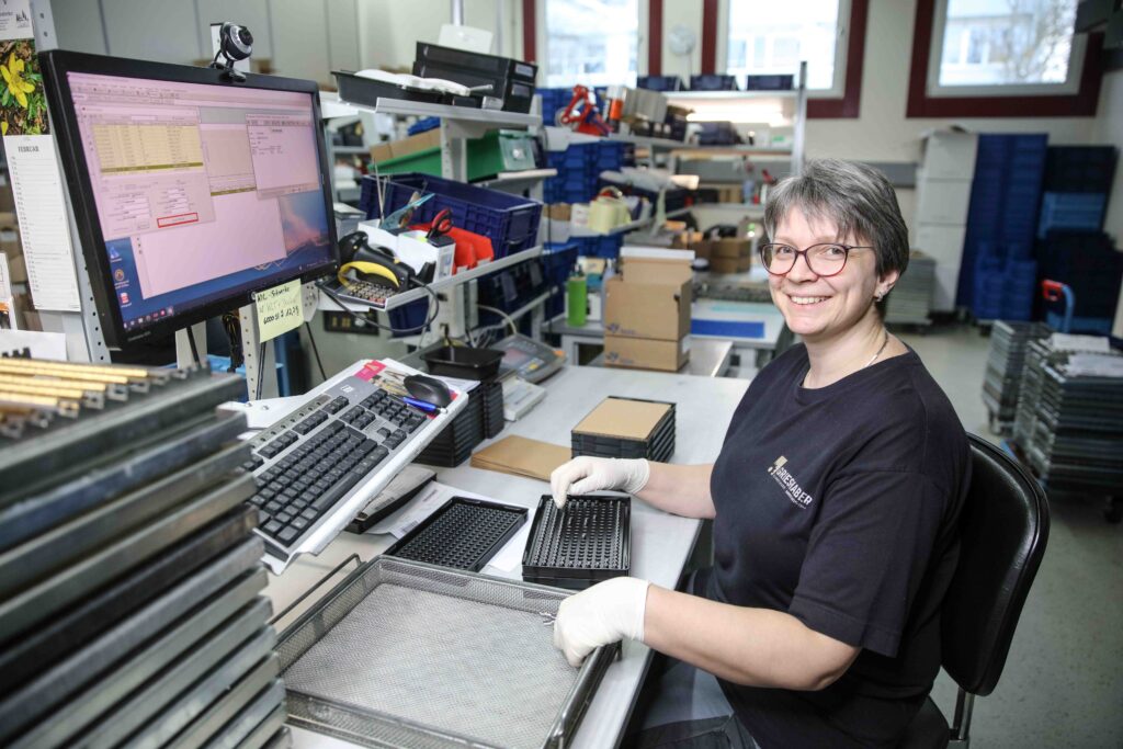 Grieshaber Mitarbeiterin prüft Präzisionsmetallteile vor dem Versand